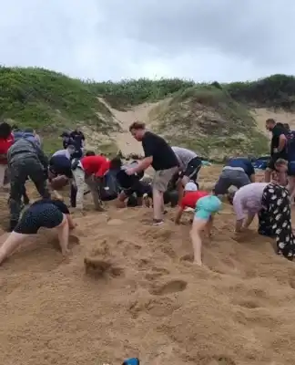 Woman rescued after beach trench collapses, trapping her for an hour
